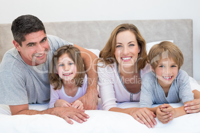 Family lying together in bed