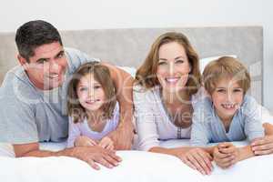 Family lying together in bed