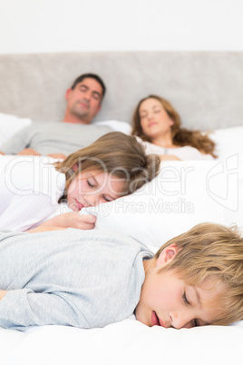 Family resting in bed