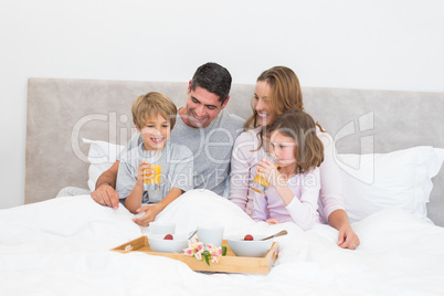 Family having breakfast together in bed