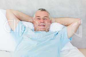 Senior man lying in bed