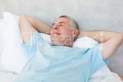 Senior man day dreaming in bed