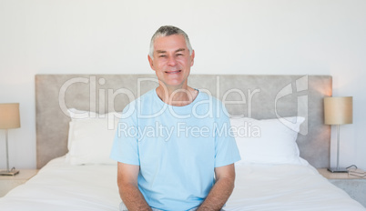 Senior man sitting on bed