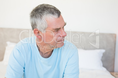 Senior man looking away on bed