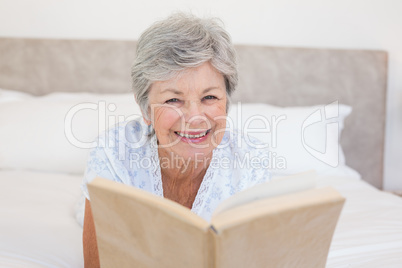 Happy senior woman reading story book