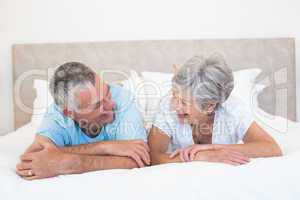 Senior couple looking at each other in bed