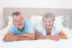Senior couple lying in bed at home