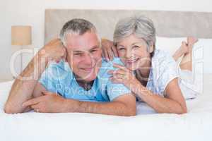Loving senior couple lying in bed