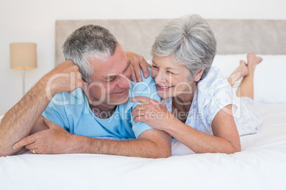 Senior couple smiling together on bed