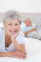 Smiling senior woman with man in bed