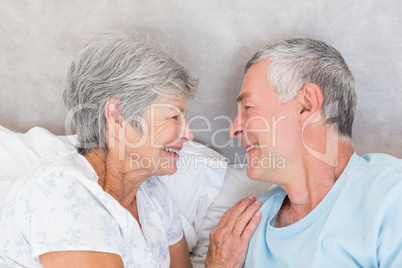 Smiling senior couple in bed