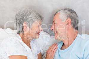 Smiling senior couple in bed