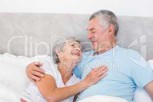 Senior man looking at wife in bed