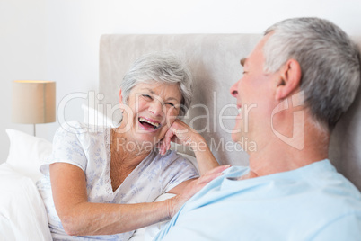 Senior woman looking at husband in bed