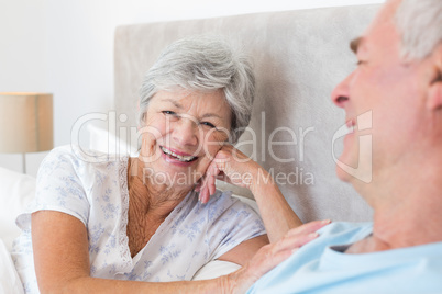 Happy senior woman with man in bed