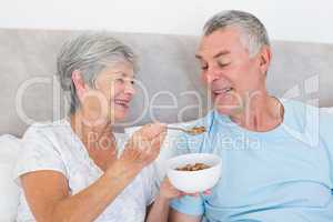 Senior woman feeding cereals to husband