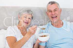 Senior woman feeding cereals to man