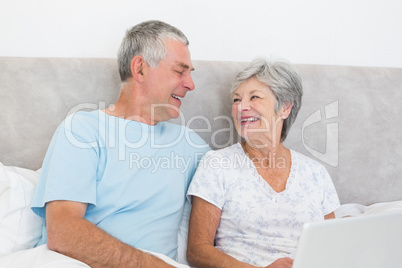 Senior couple looking at each other in bed
