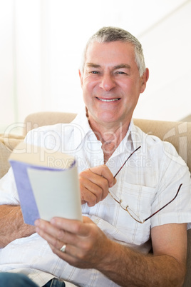 Senior man holding book and glasses