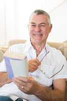 Senior man holding book and glasses