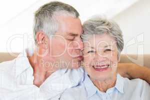 Senior man kissing wife on cheeks