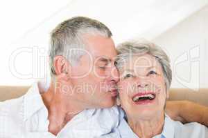 Senior man kissing happy wife