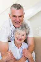 Senior man embracing wife on sofa