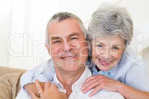 Senior woman embracing husband from behind