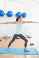 Sporty young woman stretching hands in fitness studio