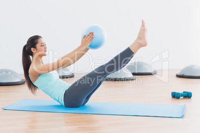 Sporty young woman stretching body in fitness studio