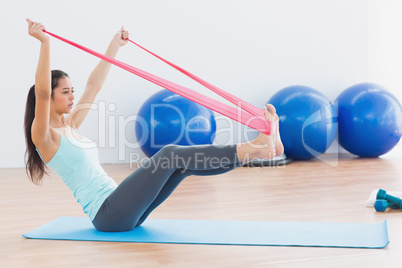 Sporty woman with exercise band in fitness studio