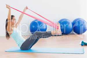 Sporty woman with exercise band in fitness studio