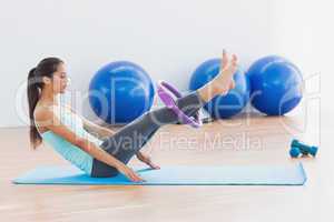 Sporty woman with exercising ring in fitness studio