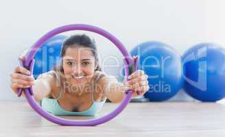Smiling sporty woman with exercising ring in fitness studio