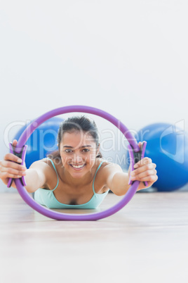 Smiling woman with exercising ring in fitness studio