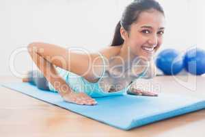 Smiling beautiful woman doing push ups in gym