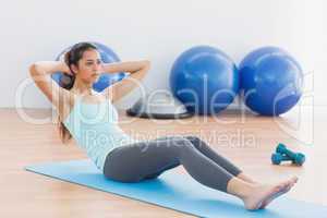 Determined woman doing sit ups in fitness studio