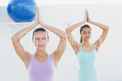 Sporty women with joined hands in fitness studio