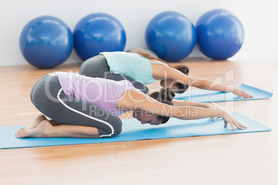 Two women in meditation pose at fitness studio