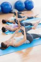 Sporty people stretching legs in fitness studio