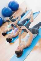 Sporty people stretching legs in fitness studio