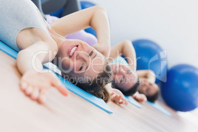 Fit class exercising in row at fitness studio