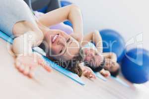 Fit class exercising in row at fitness studio