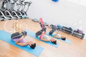 Sporty women with exercise bands in fitness studio