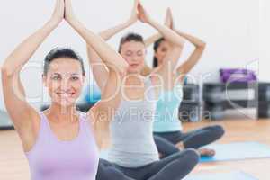 Women with joined hands at fitness studio