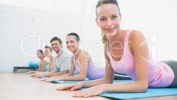 Portrait of fit class exercising at fitness studio