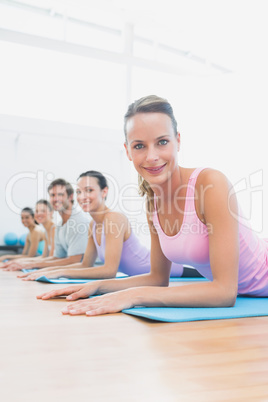 Portrait of fit class exercising at fitness studio