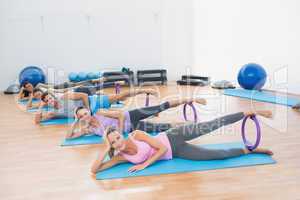 Sporty people with exercising rings in fitness studio