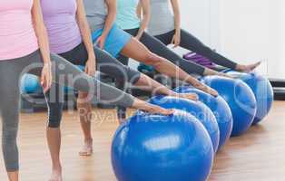 Low section of class with exercise balls at fitness studio