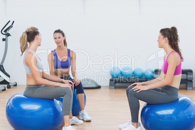 Sporty young women sitting on exercise balls